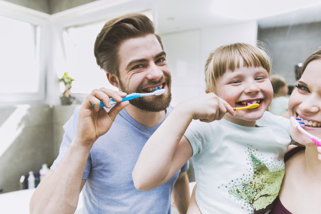 daughter parents brushing teeth